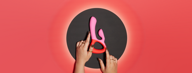 Image of hands touching Clutch Rabbit vibrator on a black hole and red gradient background
