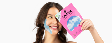 woman wearing an Unbound Lazies calming mask on her face and holding packaging over her eye