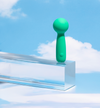 Green handheld device on a clear platform with a blue sky background